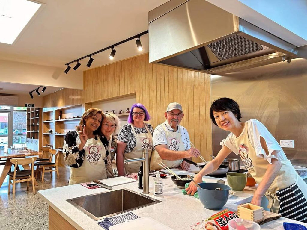 日本の家庭料理教室で料理をつくる受講生と講師