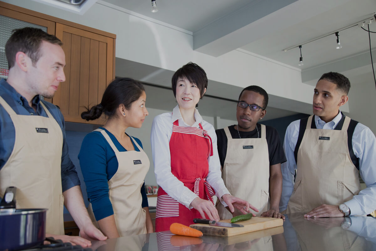 外国人の受講生に日本の家庭料理を教える料理教室の様子